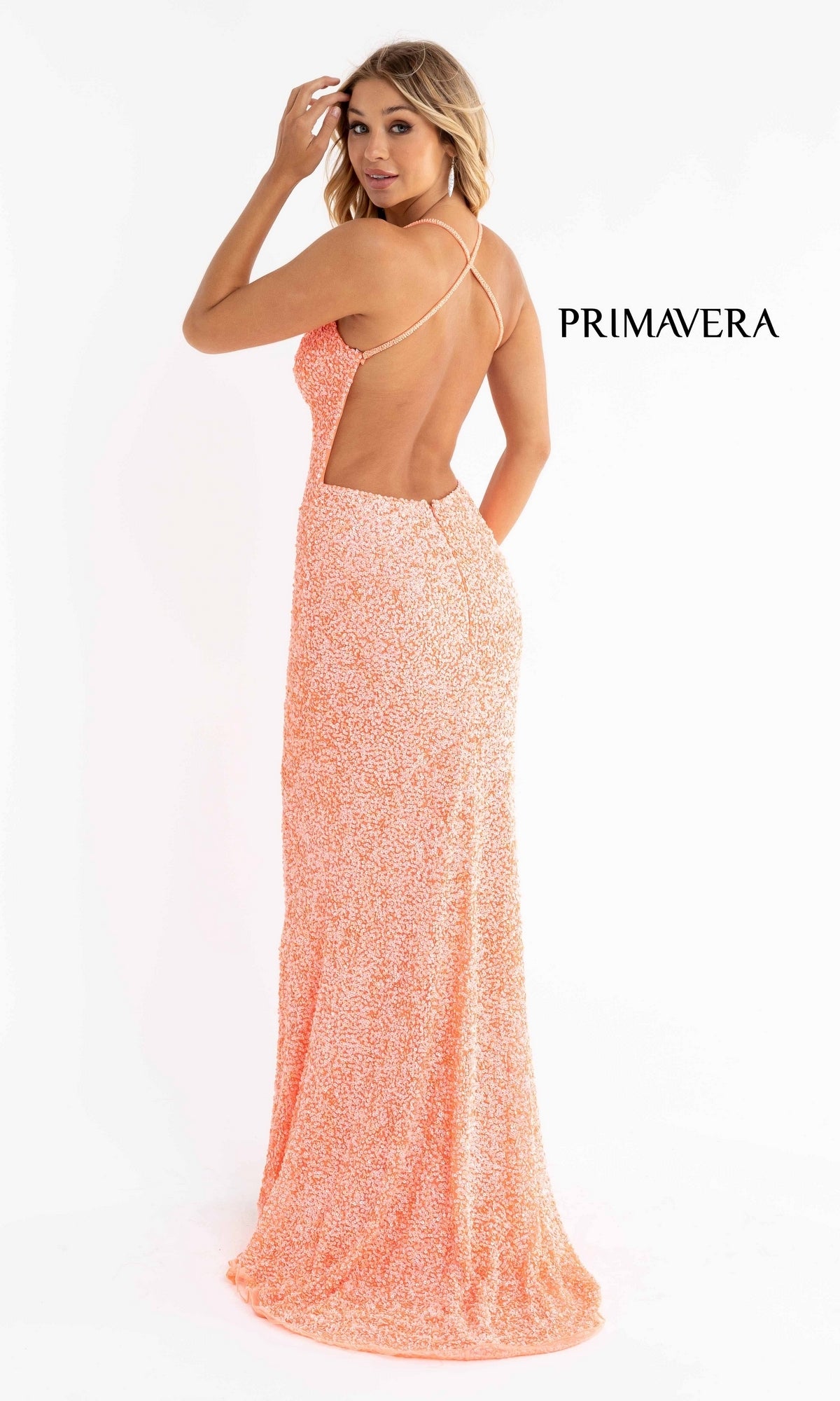 A woman models the Open-Back Bright Long Sequin Prom Dress 3291B—a peach, backless gown with a deep v-neck and spaghetti straps. The word